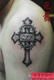 Rankos kryžius su tatuiruotės raštu