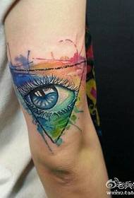 Un patrón de tatuaje de ojos triangular de color bellamente coloreado en el brazo