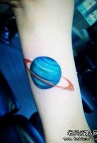 女孩的手臂，一個小的彩色的星球紋身圖案