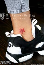 en tatuering med körsbärsblommor på vristen