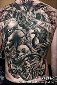 Mashkulli mbrapa me një model të lezetshëm të tatuazhit demon të mbrapa