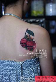 Ragazza spalle lichendu mudellu di tatuaggi di mela