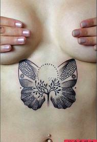 Egy szexi pillangó tetoválás egy gyönyörű nő mellkasa alatt