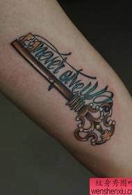 Braccio da ragazza con bel motivo colorato a forma di chiave e lettera