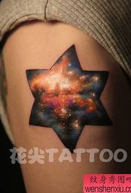 Brazo cun patrón de tatuaxe estrela e estrela de seis puntas