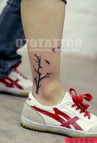 uma tatuagem de árvore no tornozelo