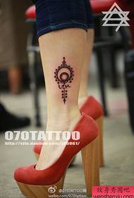 tornozelo da garota sexy em um pequeno padrão de tatuagem fresca