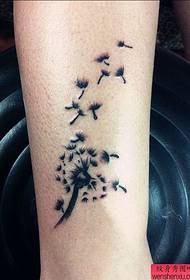 un piccolo modello di tatuaggio di tarassaco alla caviglia fresco