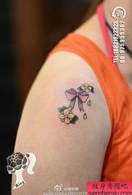 ένα μικρό και λεπτό μοτίβο τατουάζ floral τόξο στον ώμο ενός κοριτσιού