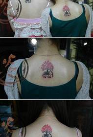 ragazza con schiena elefantino e piccolo albero tatuaggio