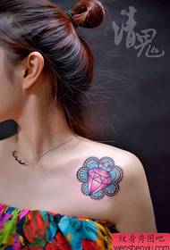 piccolo e bellissimo motivo a tatuaggio con diamanti colorati sulla spalla della ragazza