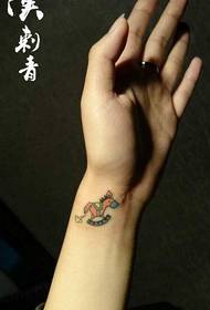 a small Trojan tattoo with a small wrist