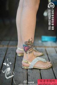 O tornozelo da menina é um padrão de tatuagem de coroa de amor pequeno e popular