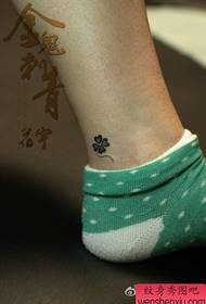 klein klavertje vier tattoo-patroon op de enkel van het meisje