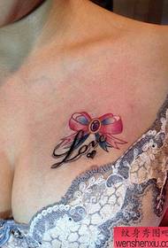belle poitrine avec un beau motif de tatouage arc et lettre