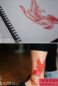 un piccolo tatuaggio del pesce rosso sulla gamba