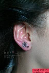 लड़की कान एक छोटे कमल टैटू पैटर्न