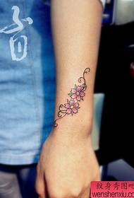 djevojčino zapešće mali uzorak tetovaže cvjetanja trešnje