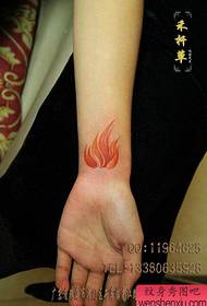 djevojčino zapešće na prekrasnom uzorku tetovaže plamena u boji