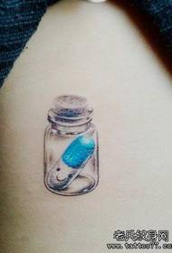 Un grazioso modello di tatuaggio con bottiglia di pillola
