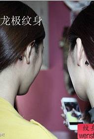 Девушкам на ухо популярная татуировка из попскинской сливы