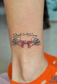 girl's legs with small bow and wings tattoo pattern