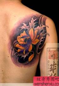 Japoński tatuażysta działa na kolorowym tatuażu lotosu