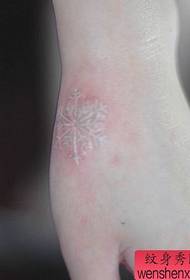 девојка рука мали узорак тетоваже с белим пахуљицама