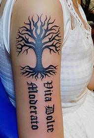 Kleine boom met Engelse woorden met tatoeages op de arm