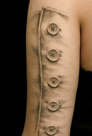 model de tatuaj realist cu nasturi pe brațul mare