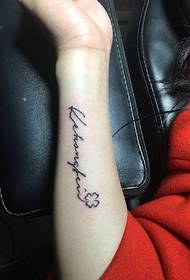 Мала свежа англиска слика за тетоважа од надворешната страна на црвената убава женска зглоб