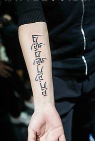 Immagine del tatuaggio sanscrito chiaramente individualizzata sulla parte esterna del braccio