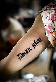 dekliška roka znotraj preproste angleške besede tattoo tattoo