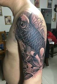 foto tatuaggio braccio bianco e nero con calamari e loto
