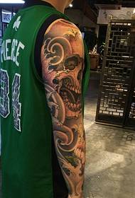 immagine del tatuaggio in bianco e nero del braccio maschile vestito da palla verde