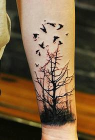 grančica i slika malenog lastavica u kombinaciji s tetovažom ruku