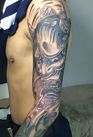 black and white tattoo image covering the entire arm