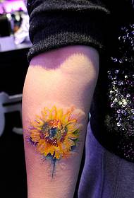 un tatuaggio di girasole che cade sul braccio