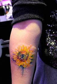 un tatuaje de girasol que cae sobre el brazo